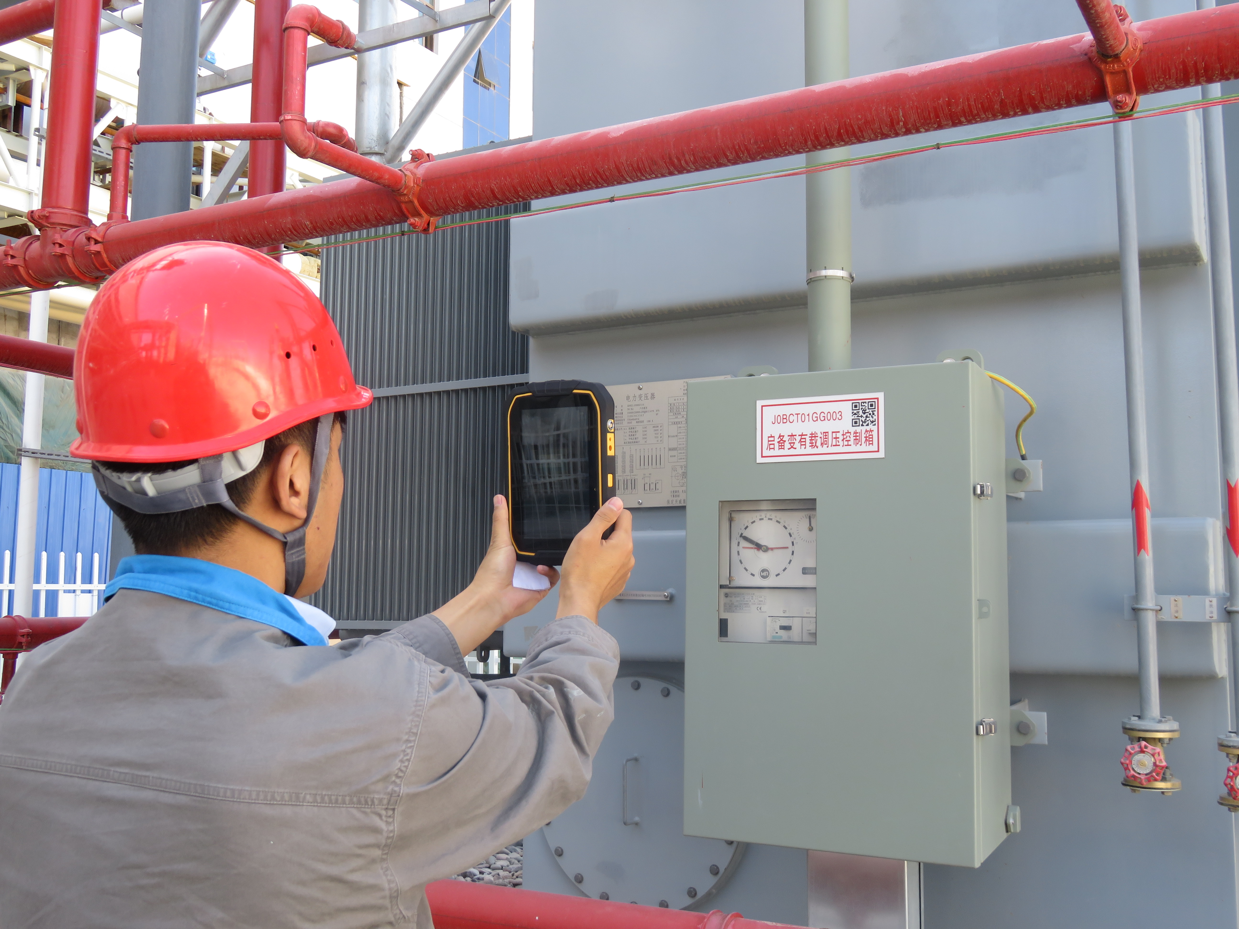 设备管理人员用点检仪扫描启备变标识牌二维码,对设备运行工况进行